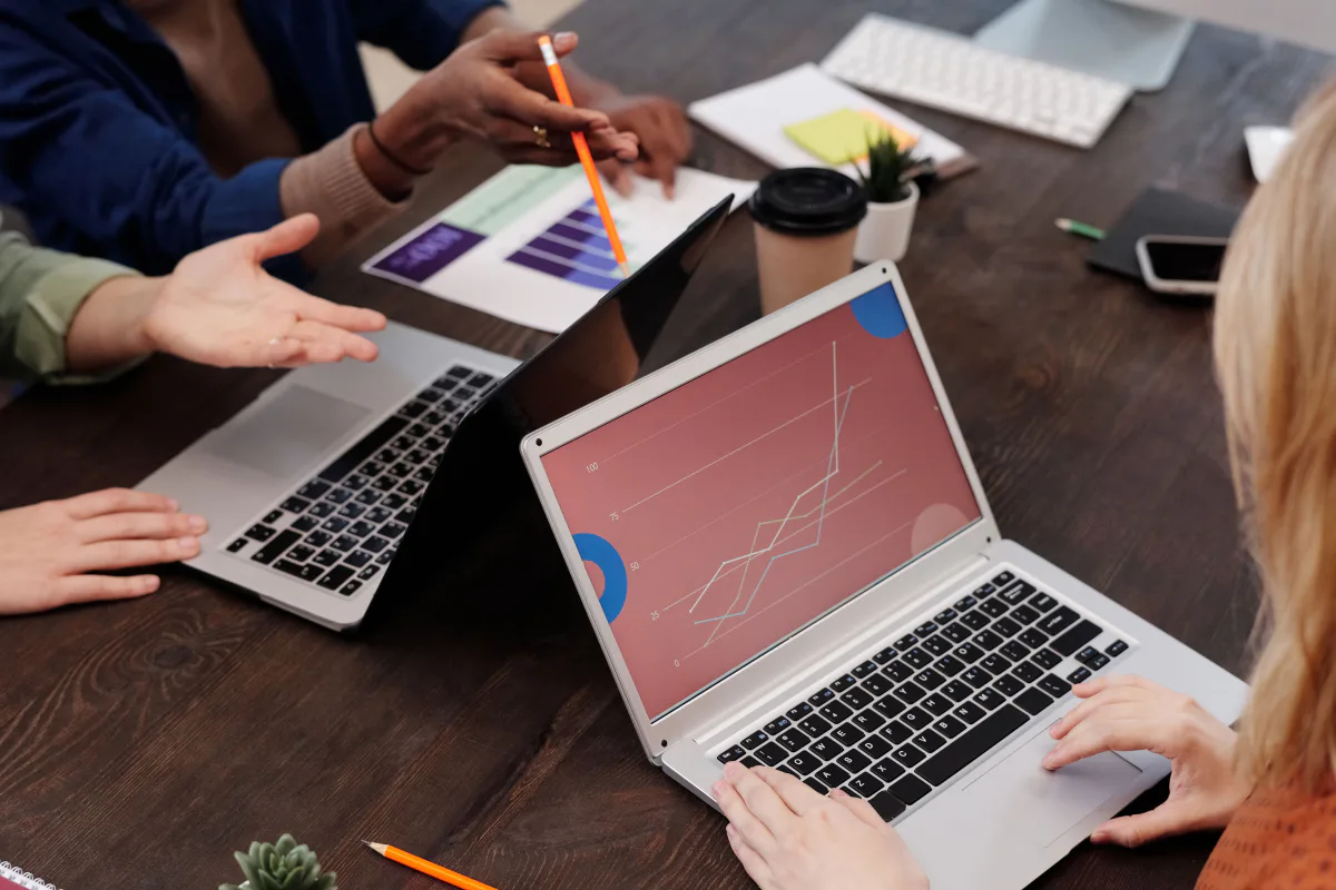 A team reviewing e-commerce growth charts on laptops